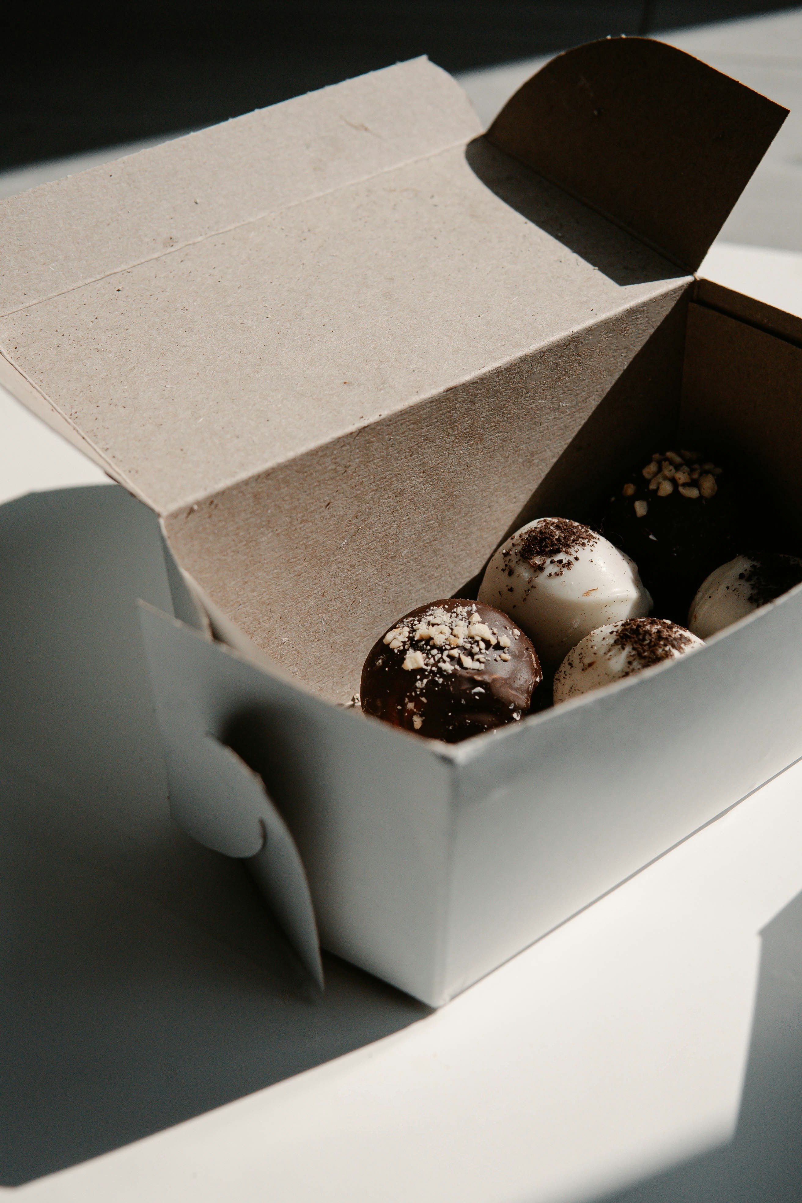 white and brown chocolate coated cookies in brown cardboard box